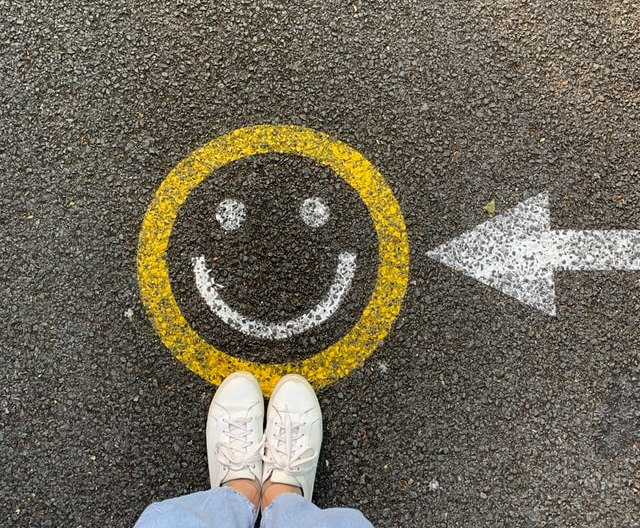 A painted smiling face and direction arrow on a road surface